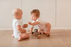 Waiting Cute little babies playing with wooden blocks