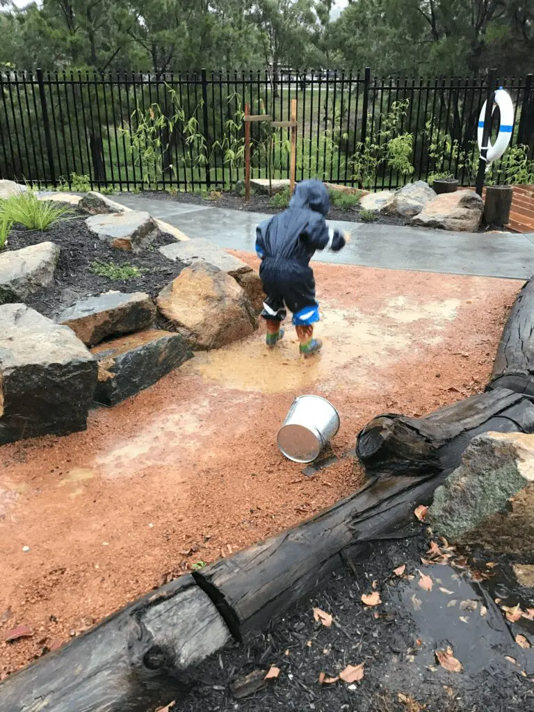 Child in gumboots playing in the rain Child in gumboots playing in the rain