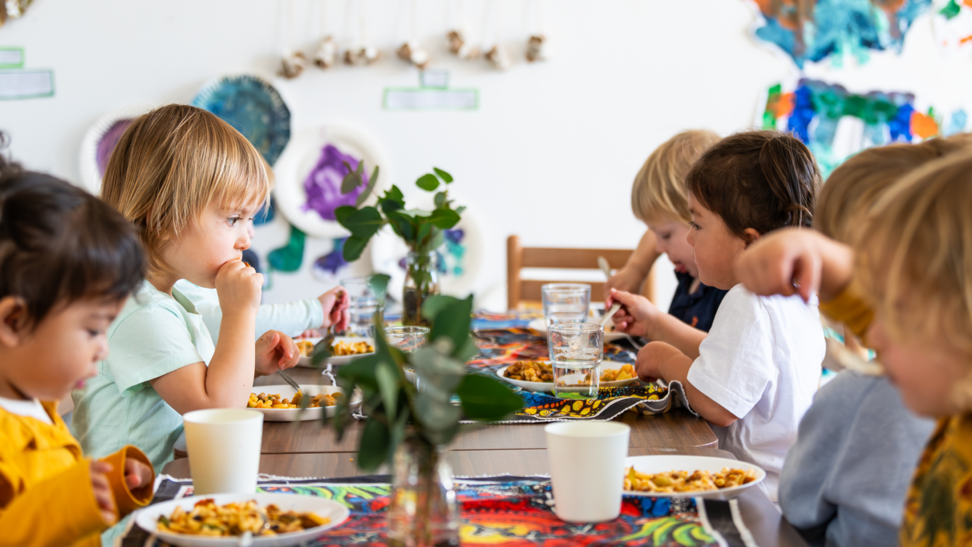 Young children eating around a table